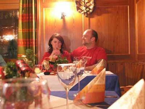 Hier sehen sie ein Ehepaar, das im weihnachtlich dekorierten FrÃ¼hstÃ¼ckssaal den Aufenthalt im Hotel genieÃŸt.